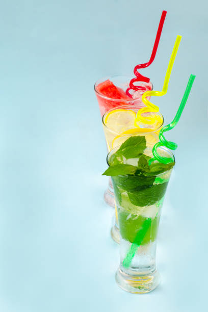 Three glasses of chilled drinks on a blue background, lemonade, watermelon lemonade, mint lemonade, iced drinks to quench your thirst on a hot summer day