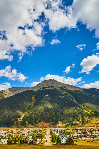 istock Small mining town in the country with tall mountain range and blue sky 1491045612