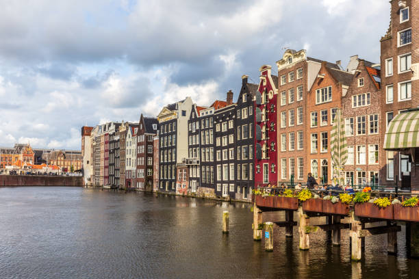 Grachtenpanden in Amsterdam met avondschemering Amsterdam, the Netherlands - May 16th, 2023: Amsterdam city and the large houses at the canal with clouds jordaan amsterdam stock pictures, royalty-free photos & images