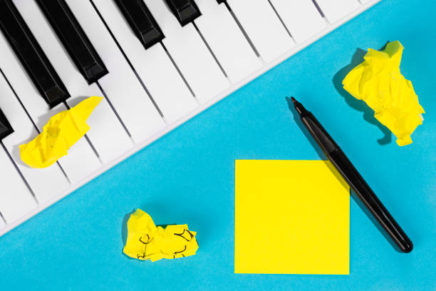 istock Yellow paper sticker and piano on a blue background, top view. 1491046183