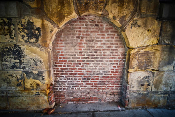 istock Stone archway eerie filled in with red brick wall 1491046409