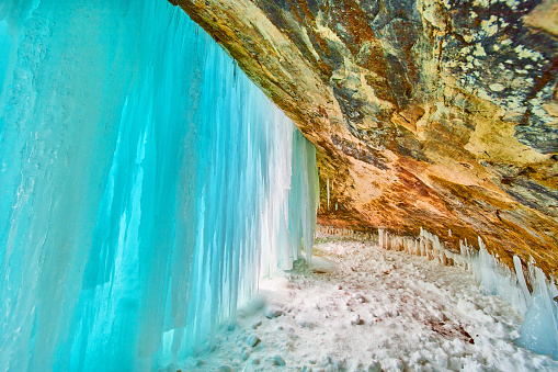 Image of Stunning blue sheet of ice covering entrance to cavern in winter