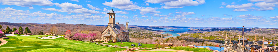 Image of Stunning panorama of golf course and church on hills next to lakes in early spring