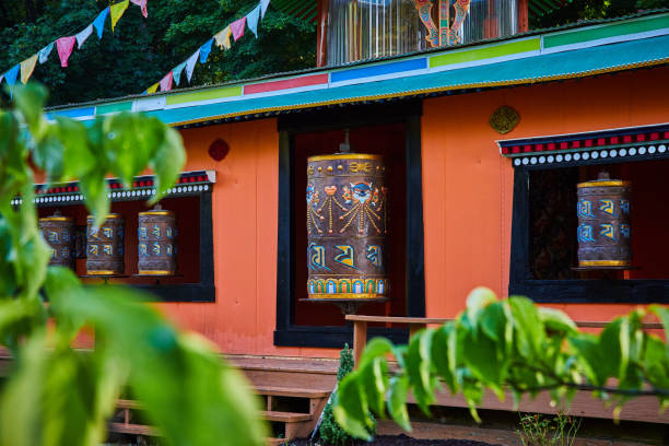 istock Temple with ornate prayer wheels through the leaves 1491049176