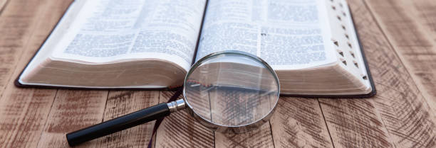 istock Book and magnifier on wooden table 1491049496