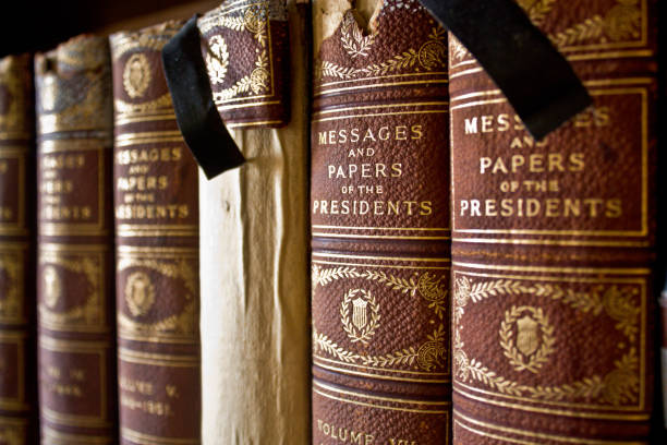 istock Old books bound with cloth lined up on a shelf 1491050359