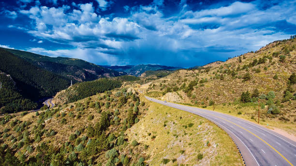 istock Open road through the rocky mountains with storm clouds 1491050555