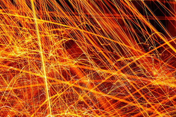 istock Orange and yellow sparks against a pavement ground at night 1491050786