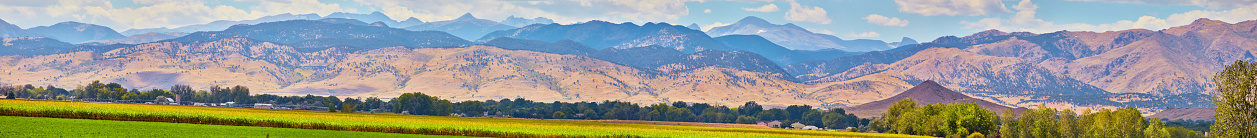 Image of Panorama of large mountain range with farming field in foreground