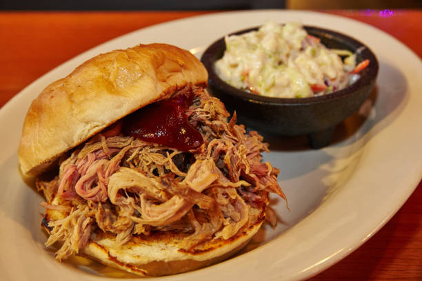istock Pulled meat burger on a white plate with a side of coleslaw 1491052359