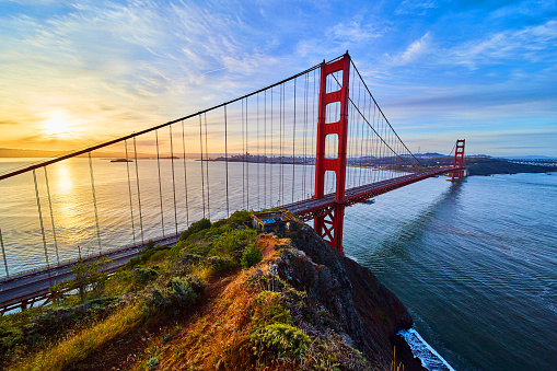 Image of Trail leading over cliffs to the Golden Gate Bridge in California at sunrise