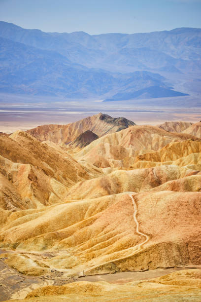 sendero a través de la formación colorida de sedimentos de zabriskie point - sand dune sand orange california fotografías e imágenes de stock