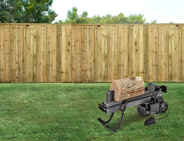 istock Electrical log splitter in a backyard with green grass and wood fence 1491054190