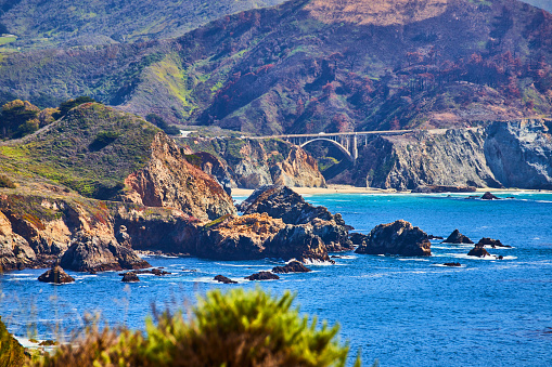 Image of View of Bixby Bridge on west coast from distance surrounded by mountains