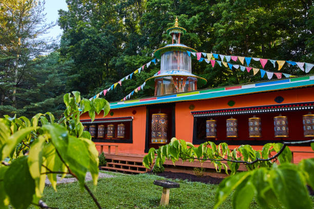 View through leaves of large prayer wheels in temple