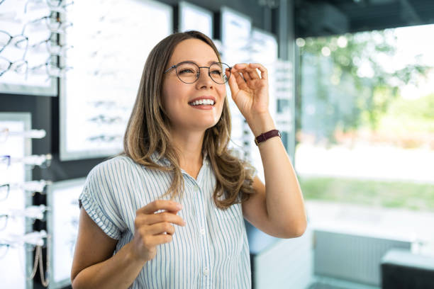 istock Fashionable woman choosing eyeglasses smiling 1491054895