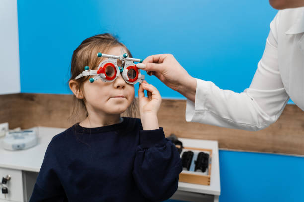 istock Pediatric ophthalmologist is wearing trial frame glasses on child. Examination with ophthalmologist for selection of trial glasses frame to examine eye visual system. 1491058540