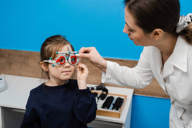 istock Pediatric ophthalmologist is wearing trial frame glasses on child. Examination with ophthalmologist for selection of trial glasses frame to examine eye visual system. 1491058541