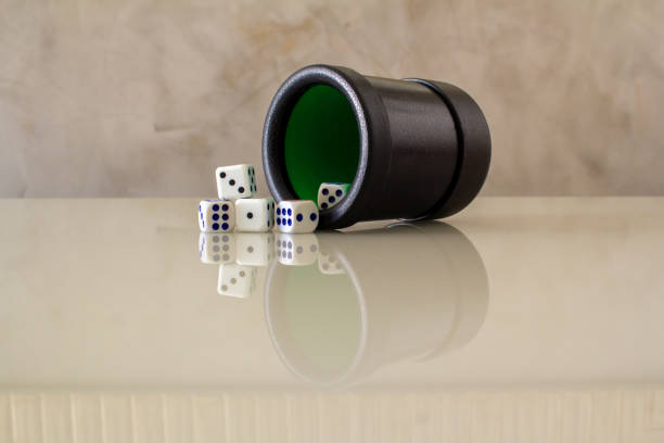 Three empty clear glass mugs appear as an unstable tower against a solid black backdrop.