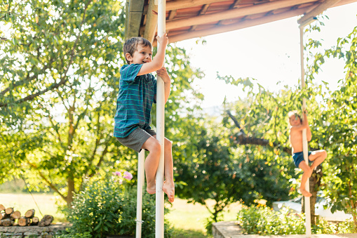 Playful children playing monkey bars in the yard