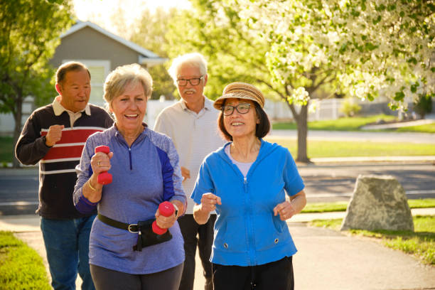 Group of Senior Aged People Power Walking in a Park A group of senior aged people power walking in a park. aging population stock pictures, royalty-free photos & images