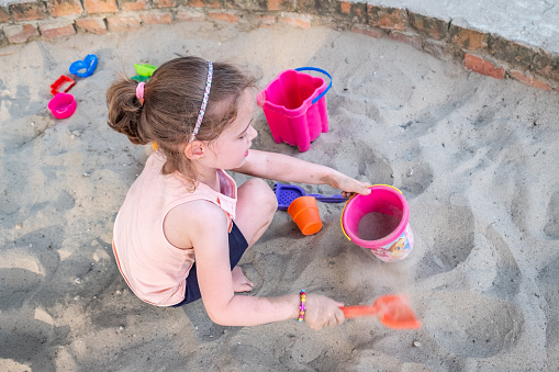 Sandbox on the children playground with colourful toys. Free time outdoors for kids. Sandpit for the entertainment.