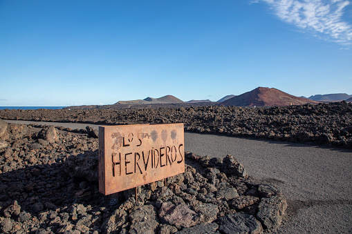Metal sign of Los Hervideros at rough lava rocks background in timanfaya National Park, Lanzarote, Canary islands, Spain