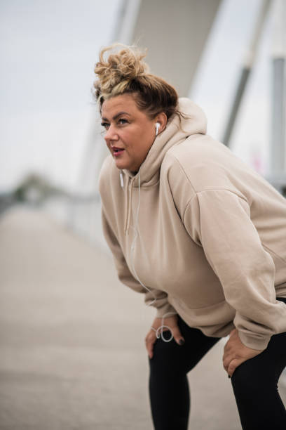 istock Exhausted fat Hispanic woman resting after a workout 1491073256