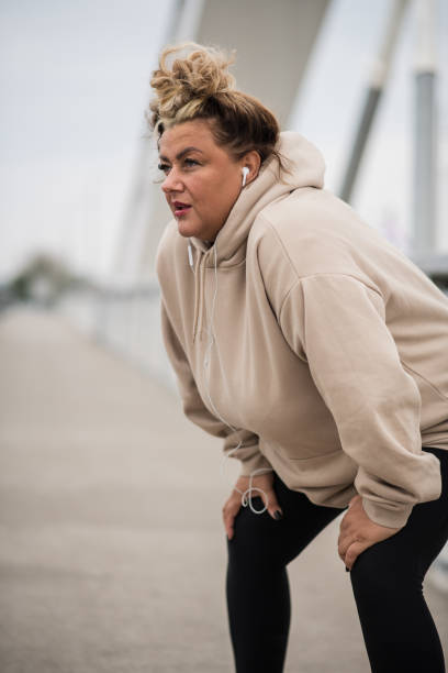 istock Exhausted fat Hispanic woman resting after a workout 1491073263