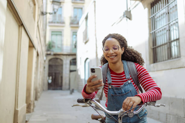 istock Young woman with a bicycle using smart phone on the street 1491084609