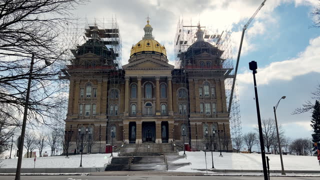 Cars Drive Along the Road Next to the Iowa State Capitol (Under Construction) in Des Moines on a Snowy But Sunny Day
