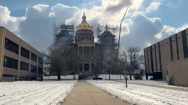 Pushing-In Shot of Walking Up the Sidewalk Toward the Iowa State Capitol (Under Construction) in Des Moines on a Snowy But Sunny Day