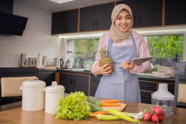 istock Happy young woman is preparing a meal in the kitchen 1491103249