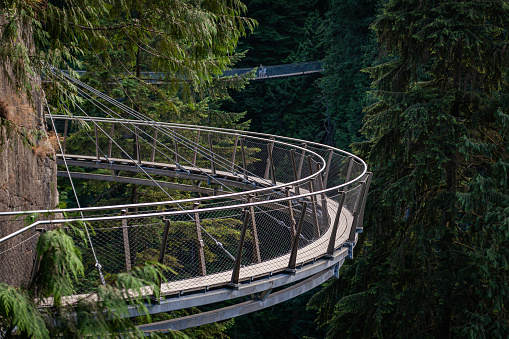 Cliffwalk's narrow walkways and grainy floors generate adrenaline-pumping trips into the forest. Not for the faint of heart, the Cliffwalk juts out from the granite cliff face above the Capilano River. It's tall and narrow, and in some sections, open walkways are all that separates you from the canyon far below. Follow the path for breathtaking views and unique perspectives on the surrounding landscape and rainforest vegetation. Built in 2011, an attraction of the Capilano Bridge, Vancouver, Northern District, state of British Columbia Canada.