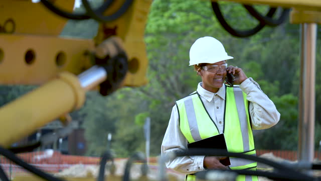 Female African-American construction worker on mobile phone