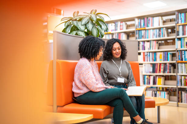 istock Hispanic Librarian Recommending A Book To A Costumer 1491106792