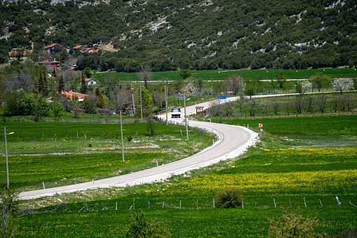 Photo of townscape of village in Anatolia Turkey. S like country road is seen on green cultivated fields.
