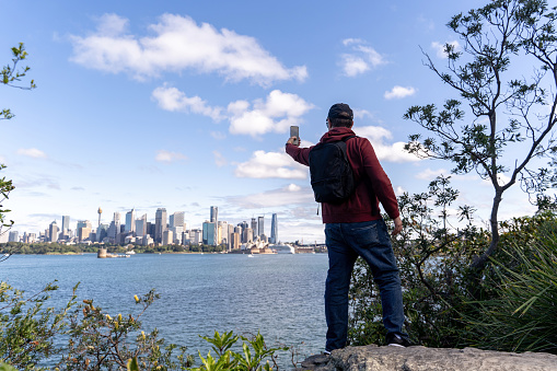 A man taking photo of Sydney Harbour from Cremorne Point