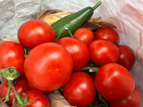 Fresh, ripe vine-ripened red tomatoes in a plastic bag
