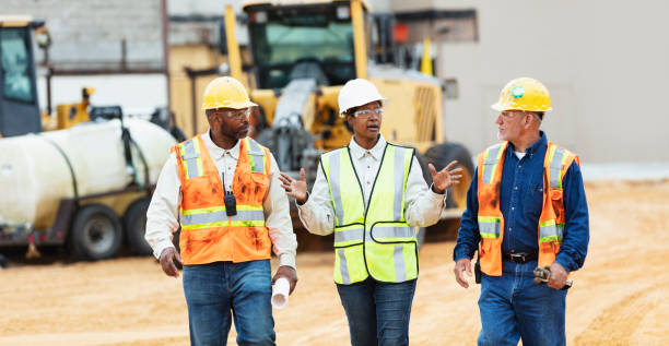 istock Woman directing construction workers, walking thru site 1491120000