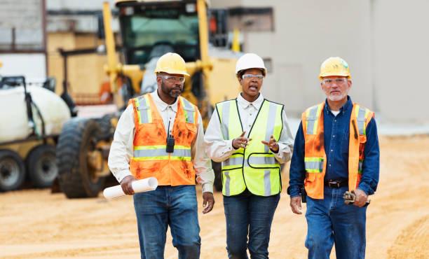 istock Woman directing construction workers, walking thru site 1491120001