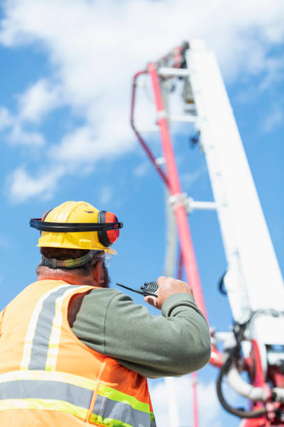 istock Construction worker directing concrete pump truck 1491125724