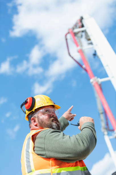 istock Construction worker directing concrete pump truck 1491125725