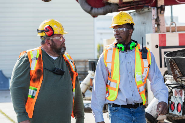 istock Two construction workers walking by concrete pump truck 1491125743