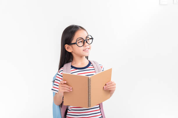 istock schoolgirl hugging book wearing backpack smiling isolated on white background 1491127633