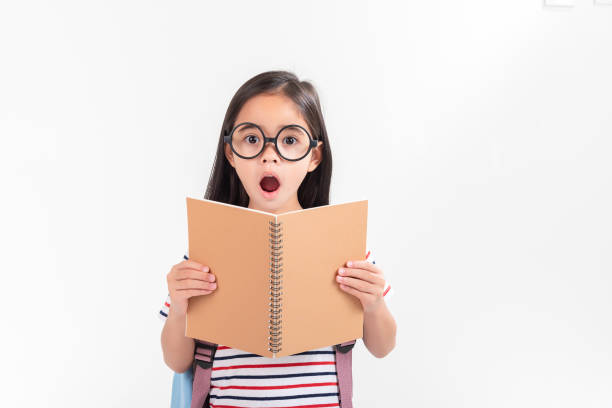 istock schoolgirl hugging book wearing backpack smiling isolated on white background 1491127637