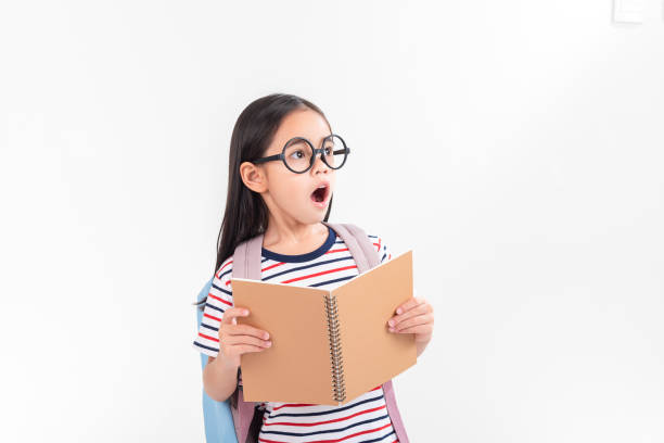 istock schoolgirl hugging book wearing backpack smiling isolated on white background 1491127639