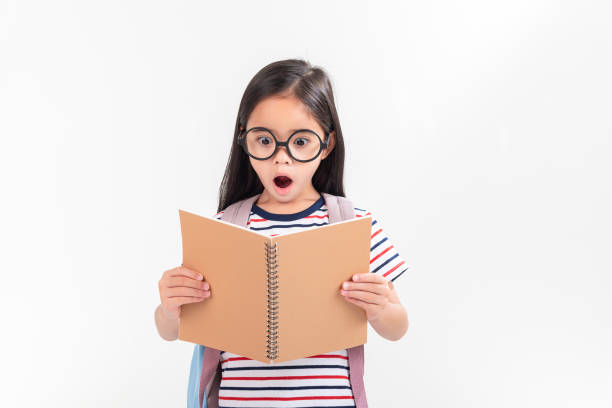 istock schoolgirl hugging book wearing backpack smiling isolated on white background 1491127653
