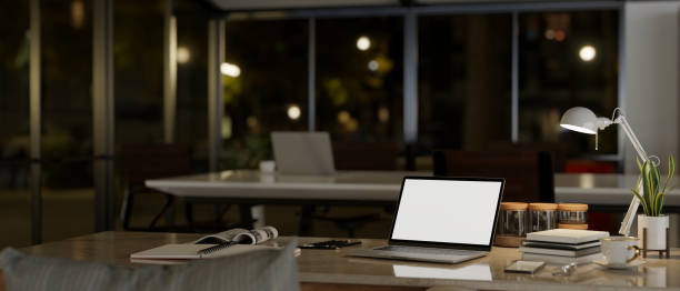 istock Workspace at night with laptop mockup, table lamp, and accessories on a table 1491129782