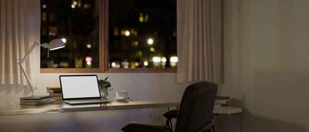 istock Modern minimal home workspace at night with laptop mockup on a table against the window 1491129783